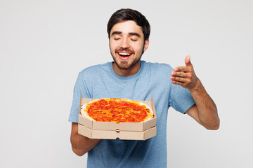 Young man wear blue t-shirt casual clothes holding italian pizza in cardboard flatbox feel scent...