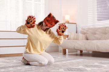 Quadrobics. Woman wearing fox mask and gloves at home