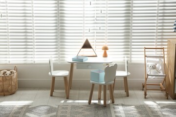 Small table, chairs and decor in stylish playroom. Interior design