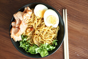 Japanese ramen with egg on black bowl in close-up