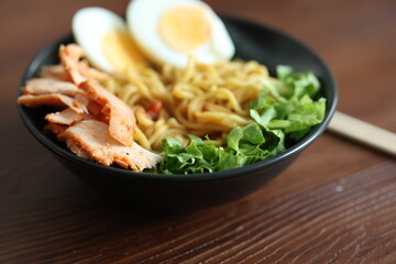 Japanese ramen with egg on black bowl in close-up