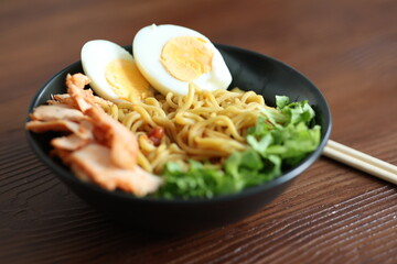 Japanese ramen with egg on black bowl in close-up