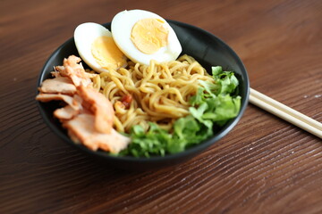Japanese ramen with egg on black bowl in close-up