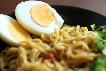 Japanese ramen with egg on black bowl in close-up