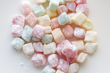 mini colors Turkish delights with roses on a white plate	