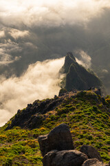 Sunlit peak emerging from dramatic mist Vertical