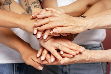 Group of People Stacking Hands Showing Teamwork and Unity