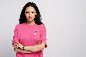 Young woman wearing pink ribbon supporting breast cancer awareness