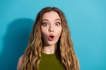 Surprised young woman against a bright background expressing amazement and emotion