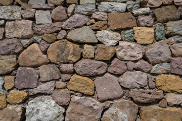 Stone wall. A wall made of large, colorful stones.