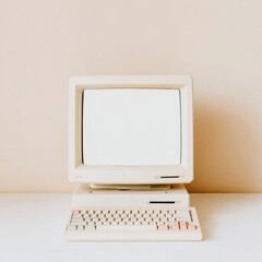 A vintage beige computer with a blank screen and a matching keyboard. The minimalist design evokes a sense of nostalgia and retro aesthetics.