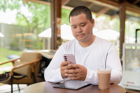 Asian plus size happy man sitting in cafe restaurant