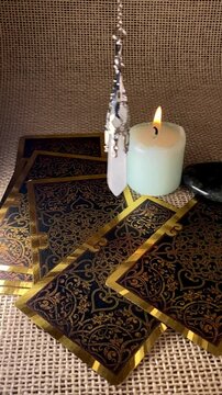 A pendulum swings gently over a burning candle and tarot cards, creating a mystical, meditative scene. Ideal for themes of divination, energy work, and spiritual rituals.