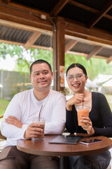 Happy young couple sitting in coffee shop