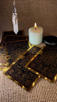 A pendulum swings gently over a burning candle and tarot cards, creating a mystical, meditative scene. Ideal for themes of divination, energy work, and spiritual rituals.