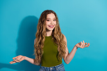 Young woman with long hair and braces gesturing playfully against a vibrant blue background