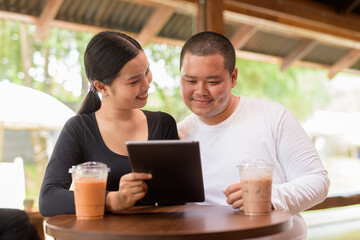 Happy young couple sitting in coffee shop