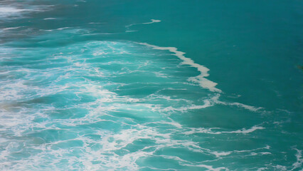 Ocean surface with turquoise water and white foam, creating a dynamic and visually appealing seascape.