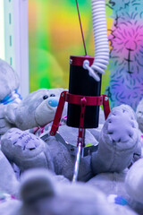 A group of beloved teddy bears is being clawed at by a machine