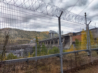 Krasnoyarsk Hydroelectric Power Station surrounded by security fencing in remote Siberian landscape