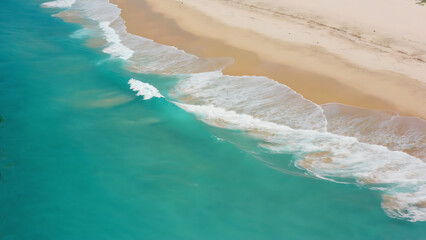Aerial view of a tropical beach with turquoise water and white sand.