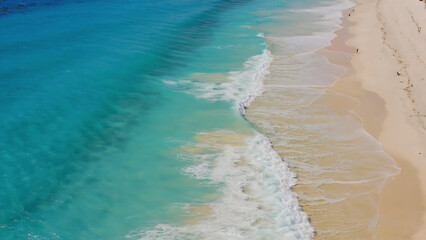 Aerial view of a tropical beach with turquoise water and white sand, perfect for vacation and relaxation.