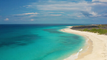Turquoise waters meet white sand beach under a partly cloudy sky, creating a serene tropical paradise.
