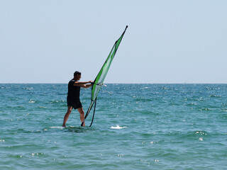 A man windsurfing in the open sea