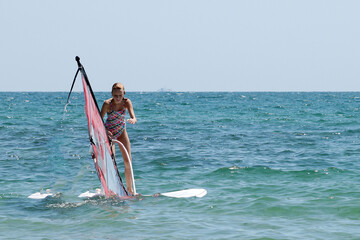 Teenage girl windsurfing in the open sea