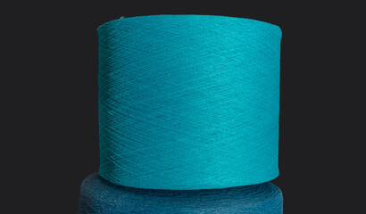 Texture of blue threads wound on spool on dark background. Blue threads for knitting. Wallpaper...