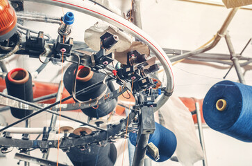 Bottom view of colored threads on spools on machines. Industrial enterprise for production of...