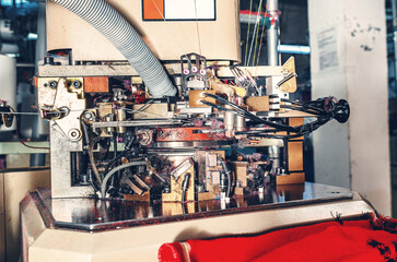 Knitting factory mechanisms. Close-up photo of machine in workshop with exhaust pipe on industrial...