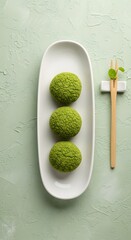 Delicious matcha mochi dessert on white plate with chopsticks and leaf garnish food photography