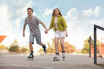 Happy couple roller skating together on street