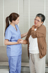 Asian female physiotherapist guiding shoulder movement of senior woman for pain relief and joint...