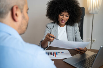 Financial expert and client reviewing business contract or investment report in modern corporate environment