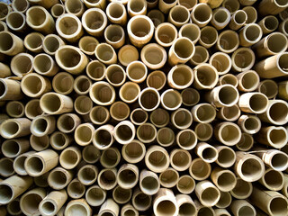 Close-up of bamboo wall with cut stems forming a pattern of round wooden shapes.