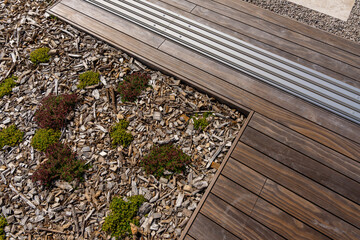 Focus sur un aménagement de jardin mettant en valeur la transition entre un caillebotis en bois et...