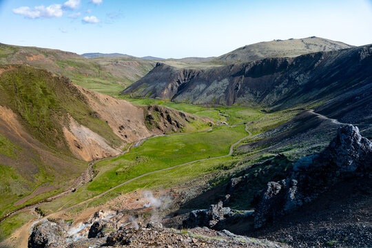 View of a lush green valley nestled among rugged hills, where steam rises gently, creating a tranquil yet striking contrast, Hverager&Atilde;&deg;i, Sveitarf&Atilde;&copy;lagi&Atilde;&deg; &Atilde;&ndash;lfus, Iceland.