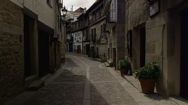 Sunlit street in Mogarraz, famed for portraits on fa&ccedil;ades and rustic architecture. Great for cultural, travel, and heritage visuals.