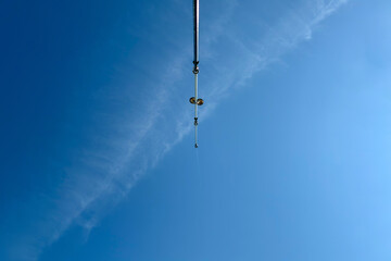 Peaceful sea fishing with a rod against clear blue sky and calm ocean water, tranquil coastal landscape with distant mountains, summer outdoor leisure and recreational activity concept.