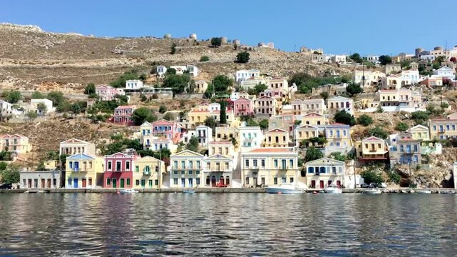 Colorful houses line the harbor of symi island in greece