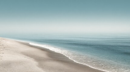 Obraz premium Serene coastal scene; calm ocean meets sandy shore