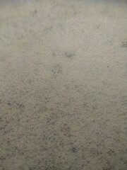A close-up, high-angle view of white foam bubbles, creating a textured surface with tiny, interconnected spheres, possibly in soapy water.