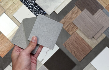 interior designer compares material samples: wood veneer, laminate, marble, stone tile, terrazzo,...