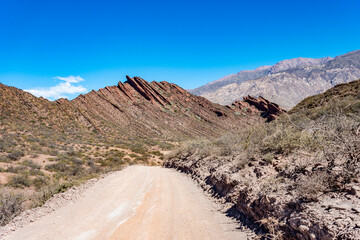 Scenic dirt road in the remote valleys of Salta, Argentina. Arid mountains and vast skies...