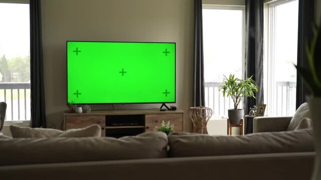 Living room setup featuring a green screen tv on a wooden tv stand unit