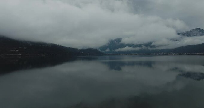Aerial view of Caldonazzo Lake with foggy dolomites in winter, Trento, Italy.