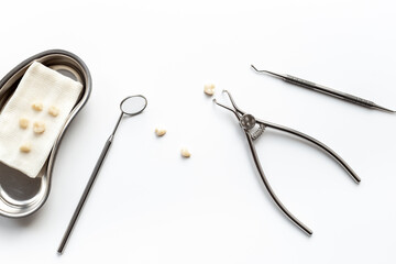 Many dental metal tools and teeth crowns in tray for dental implantation on white background....