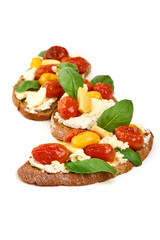 Bruschetta with cream cheese, cherry tomatoes and basil, isolated on white background